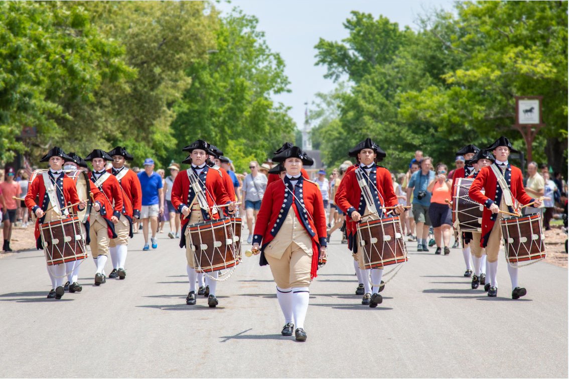 A photo of Colonial Williamsburg's Fife and Drum Corps processing down the Duke of Gloucester Street.