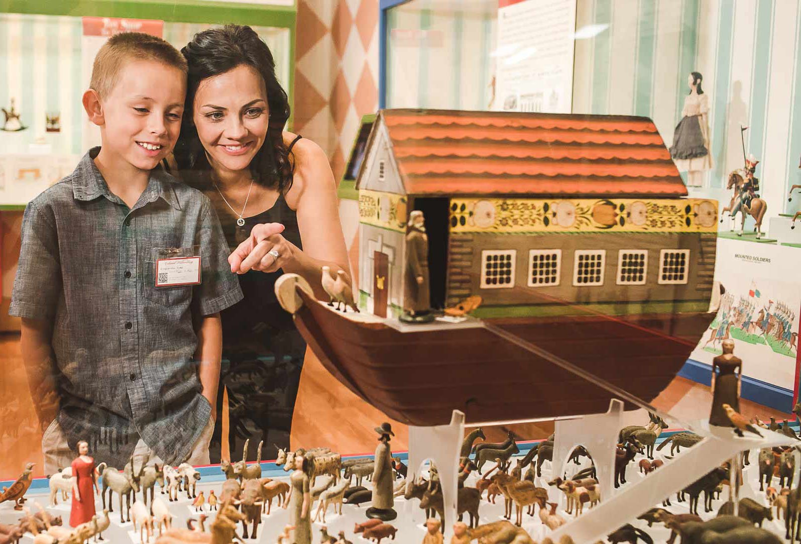 A mom and child look at the Noah's Ark piece in the German Toys in America exhibition.