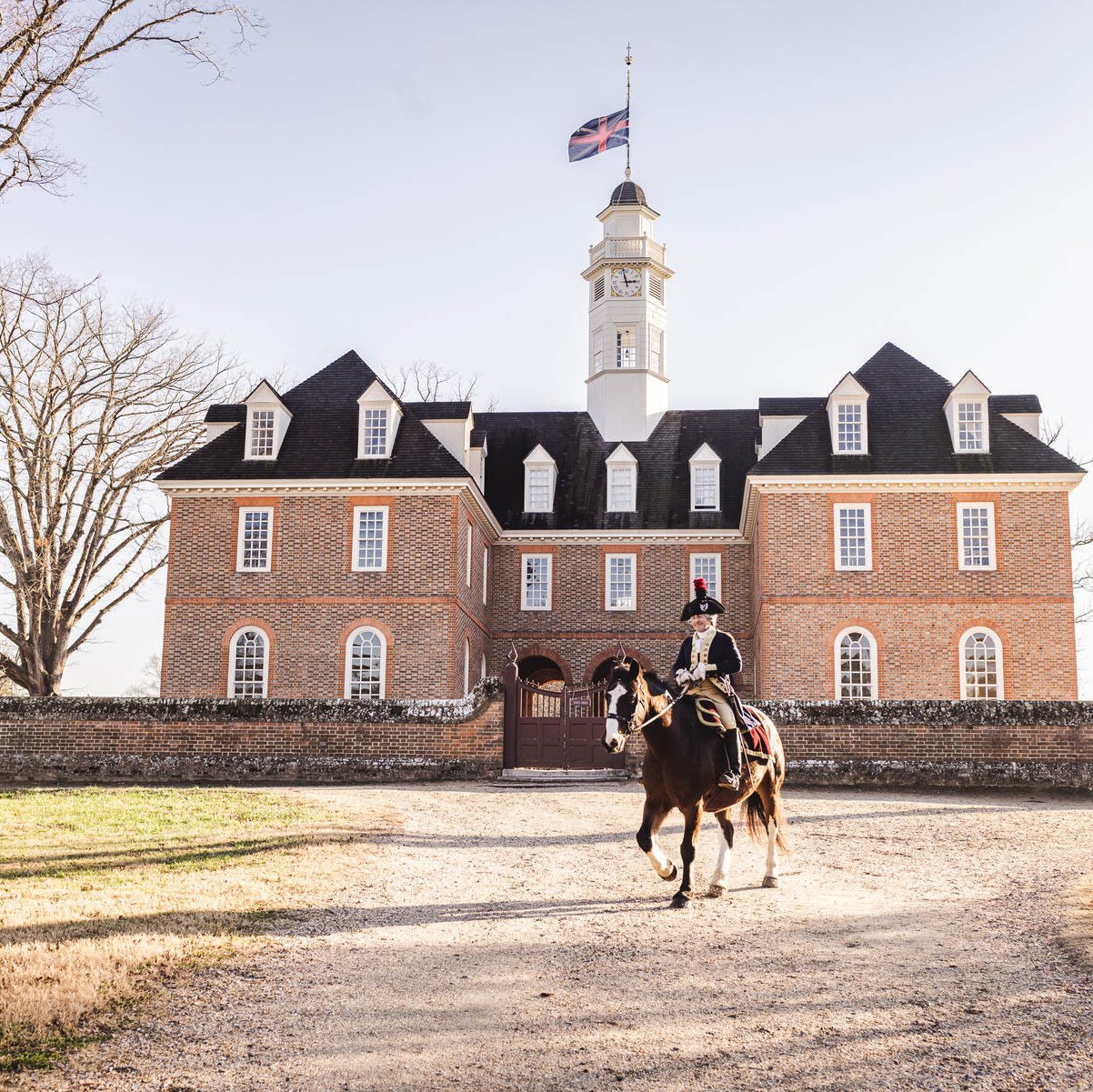 An interpreter dressed as Marquis de Lafayette sits atop a horse in front of the Capitol building.